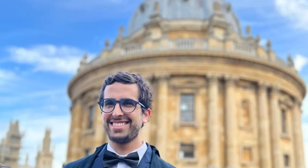Graduate standing in front of oxford university