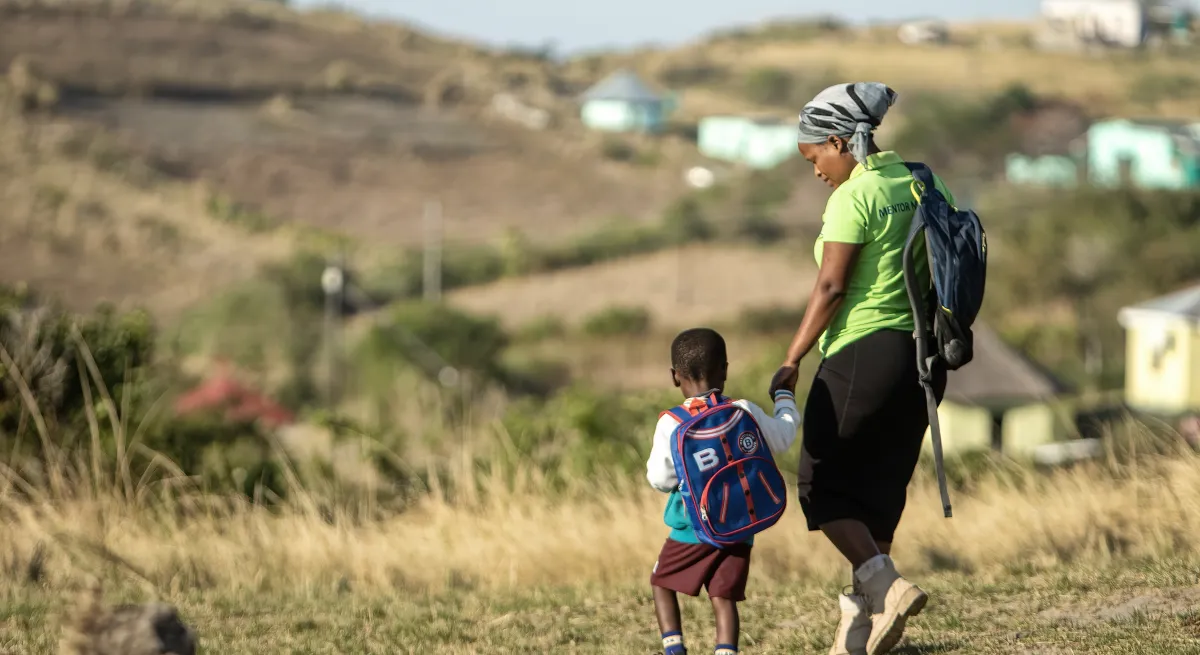 Woman walking with a little child on gras